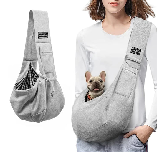 Person wearing the grey crossbody sling with a small dog looking out of the front pouch