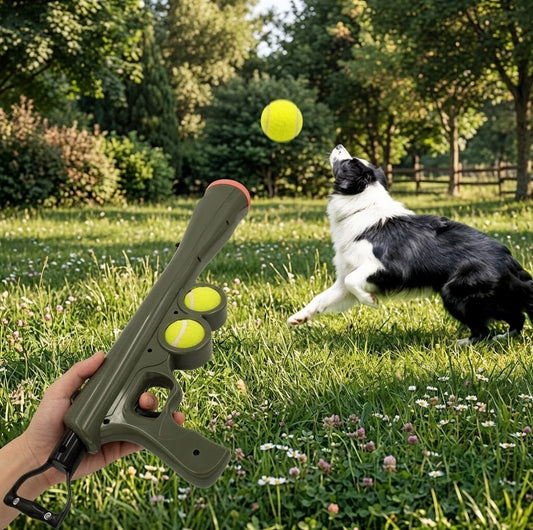 Hand holding the green ball launcher as a border collie leaps for a tennis ball