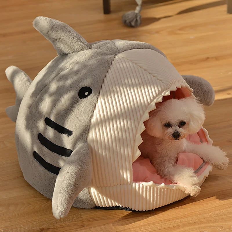 Grey shark cave bed with a small white dog lying in the opening