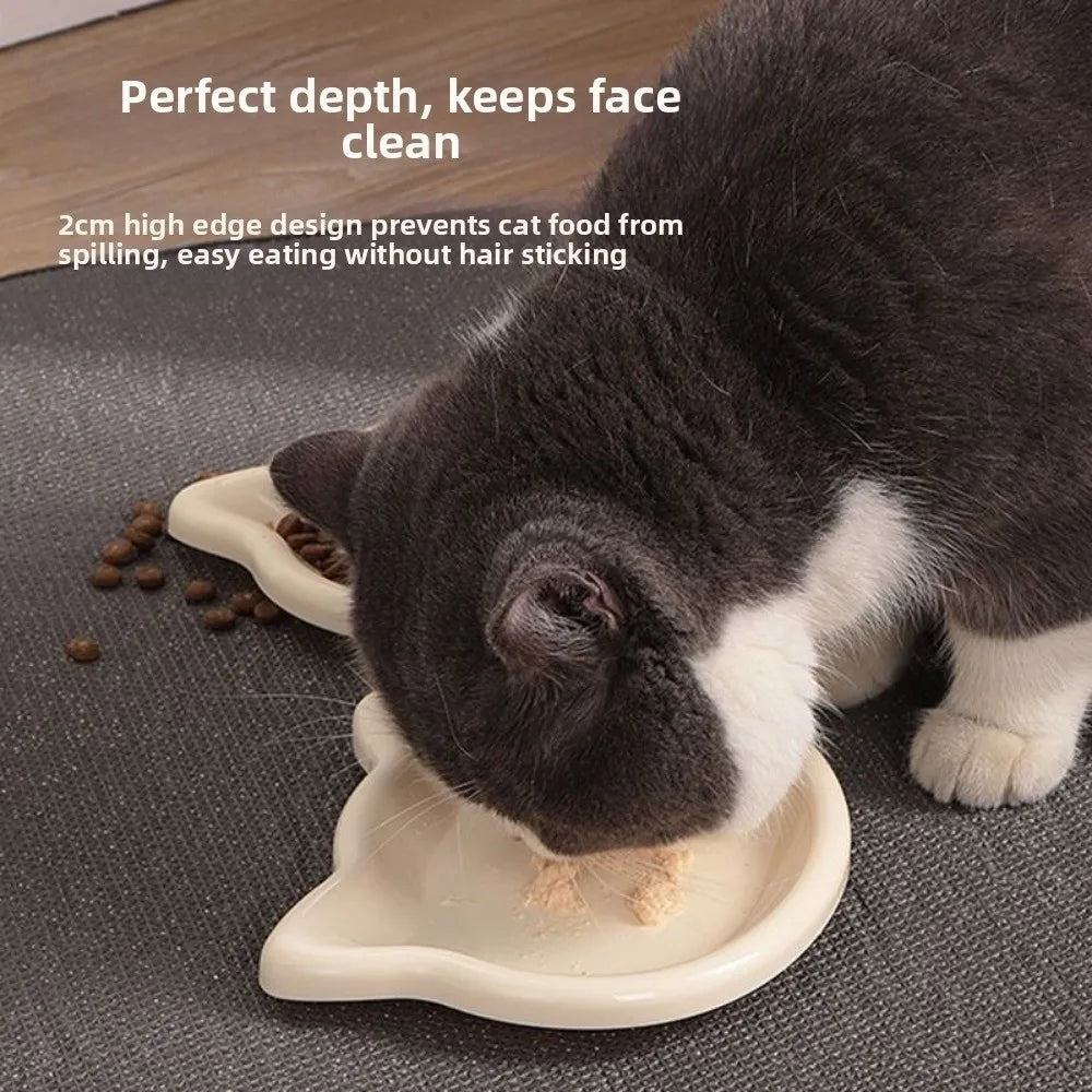 Close-up of a cat eating from a cream cat-shaped dish
