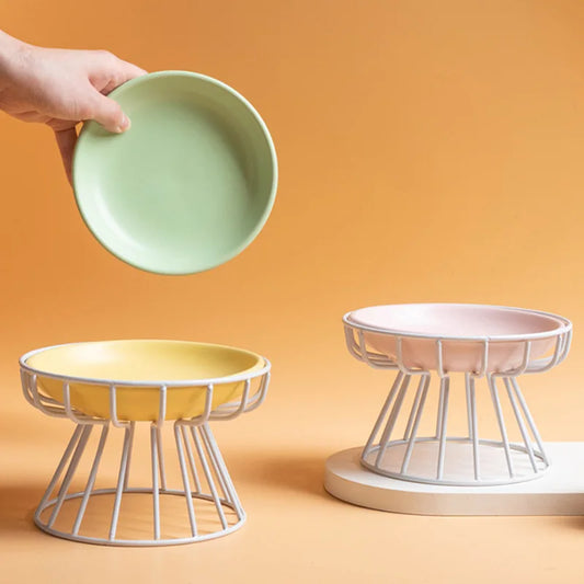 Hand lifting a sage green ceramic plate from a white wire stand